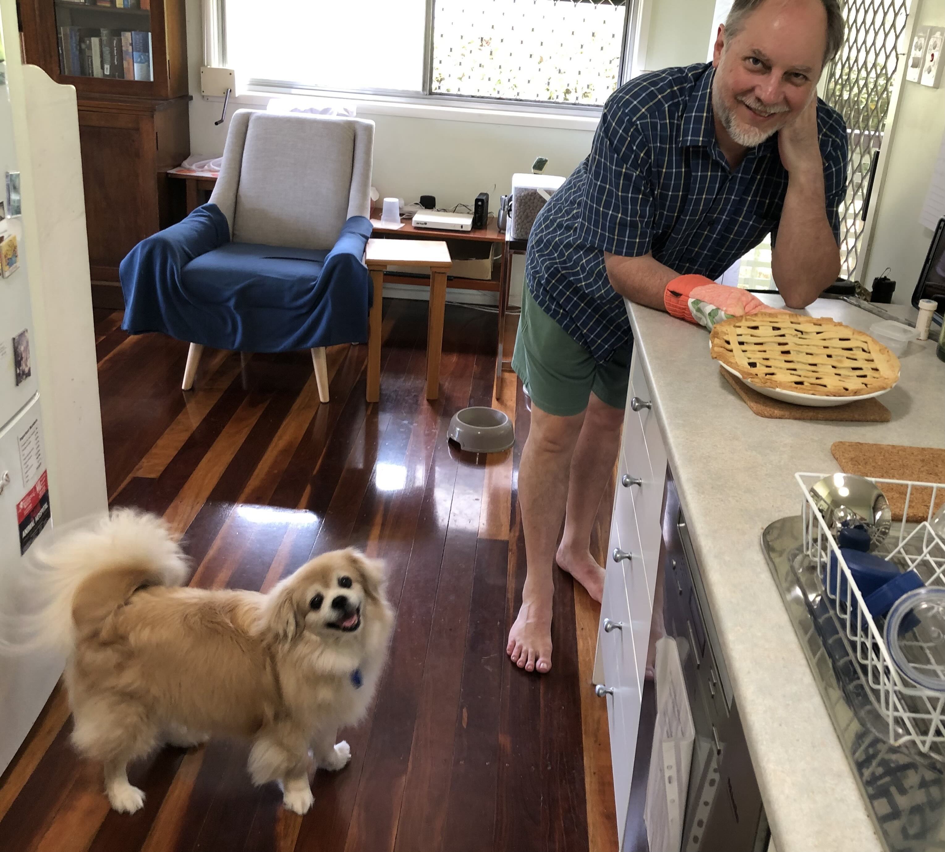 A man and a dog in a kitchen